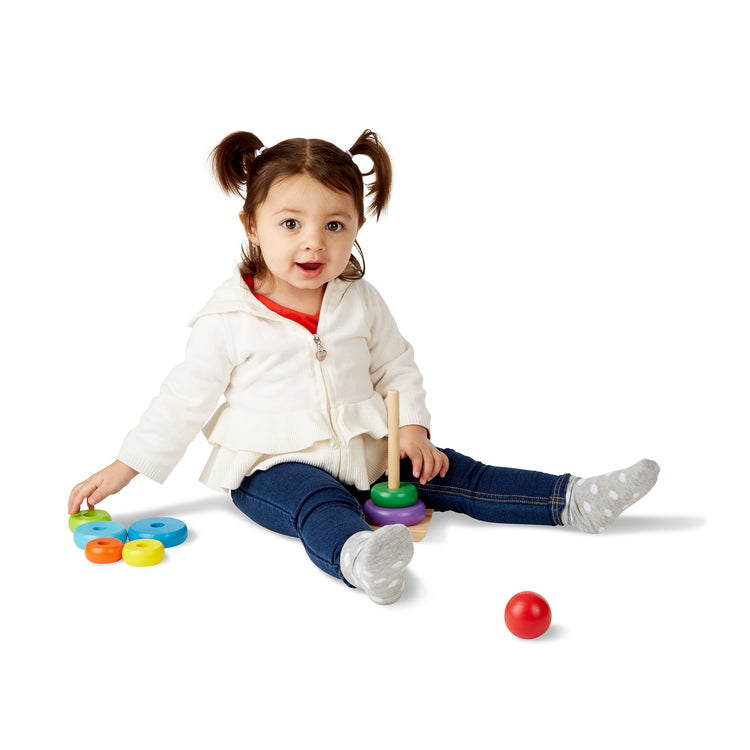 A child on white background with The Melissa & Doug Rainbow Stacker Wooden Ring Educational Toy