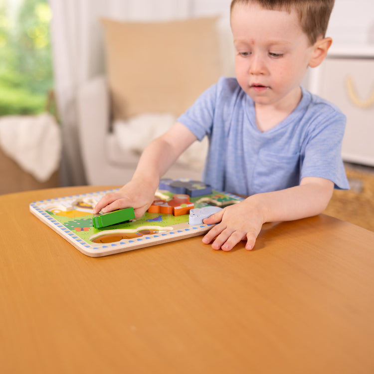 A kid playing with The Melissa & Doug Pets Wooden Chunky Puzzle (8 pcs)