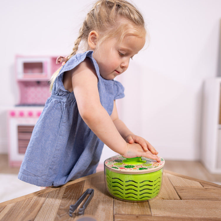 A kid playing with The Melissa & Doug Salad Spinner Play Set, Pretend Play Food for Boys and Girls Ages 3+