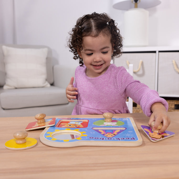 A kid playing with The Melissa & Doug® Ms. Rachel™ Wooden Peek-a-Boo Jumbo Peg Puzzle, 4-Piece with Mirror, Toddler Toys for Boys and Girls Ages 1+ Years

