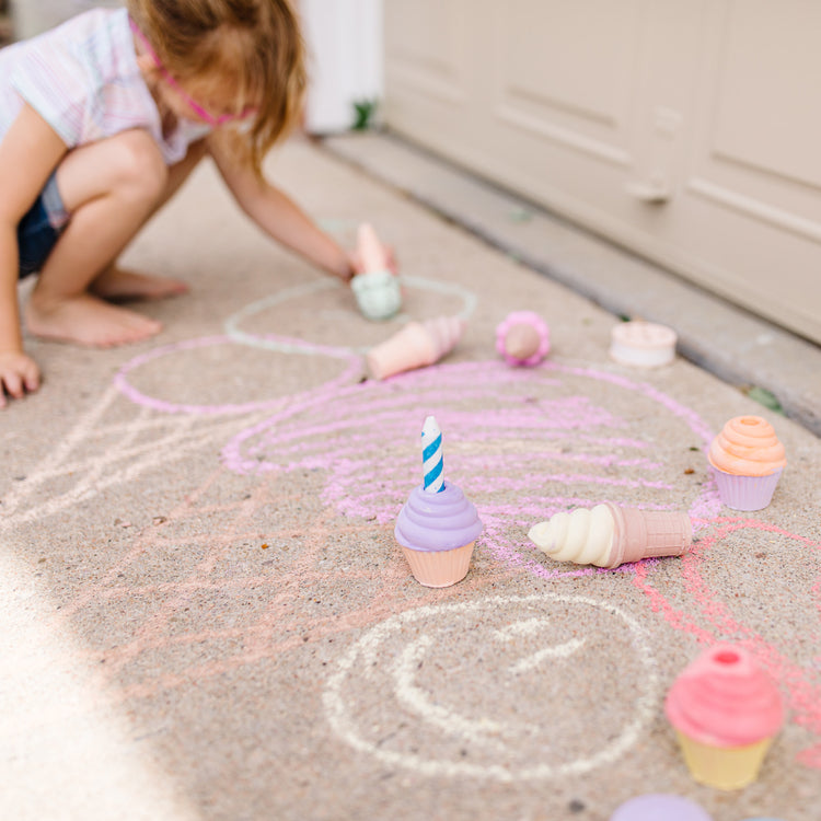 A kid playing with The Melissa & Doug Ice Cream & Cake Chalk Set