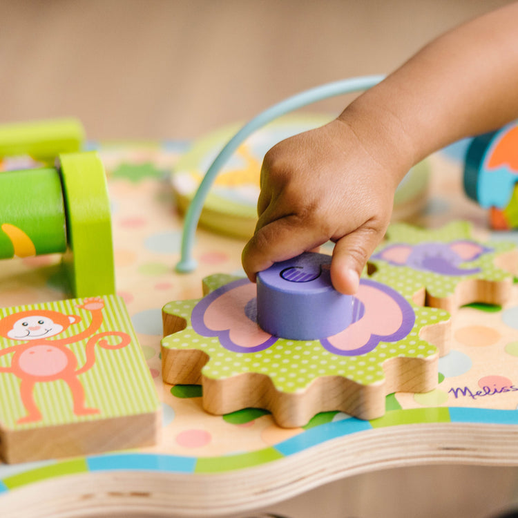 A kid playing with The Melissa & Doug First Play Children’s Jungle Wooden Activity Table for Toddlers