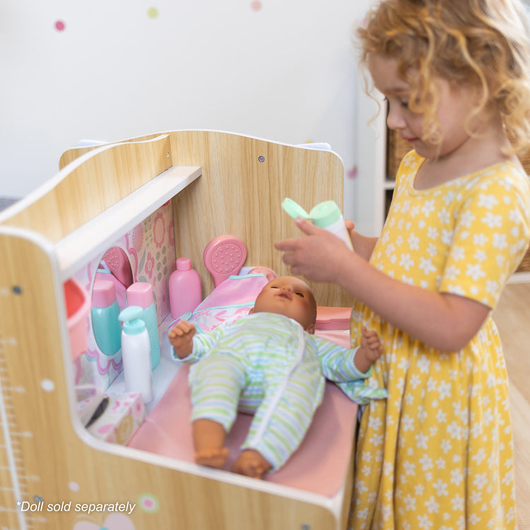 A kid playing with The Melissa & Doug Baby Care Center and Accessory Sets