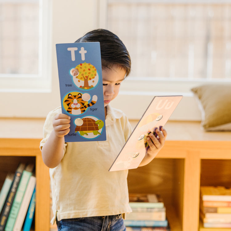 A kid playing with The Melissa & Doug Poke-a-Dot Alphabet Learning Cards