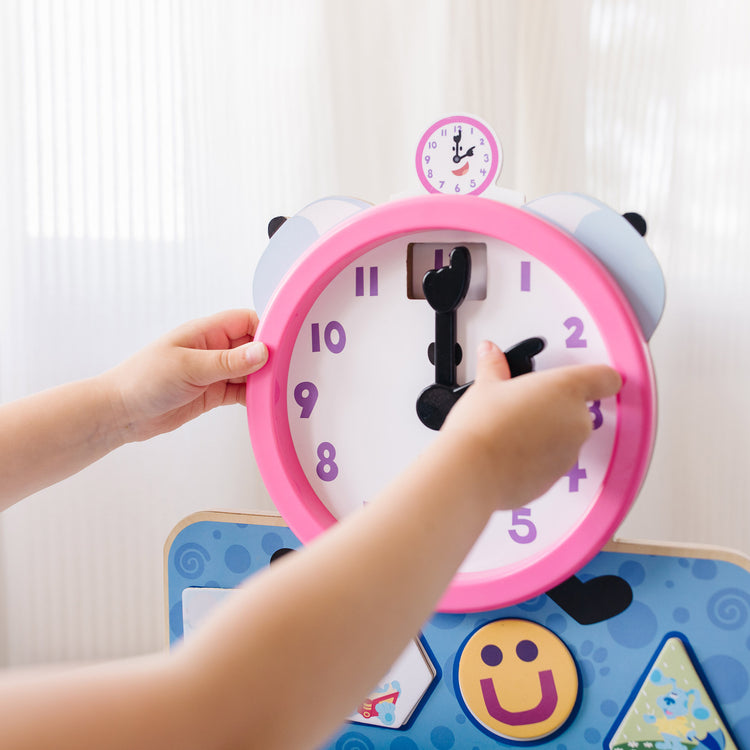 A kid playing with The Melissa & Doug Blue's Clues & You! Wooden Tickety Tock Magnetic Clock (31 Pieces)