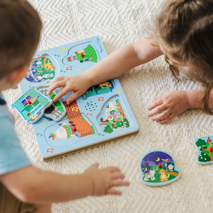 A kid playing with The Melissa & Doug Nursery Rhymes 1 Sound Puzzle - 6 PIeces