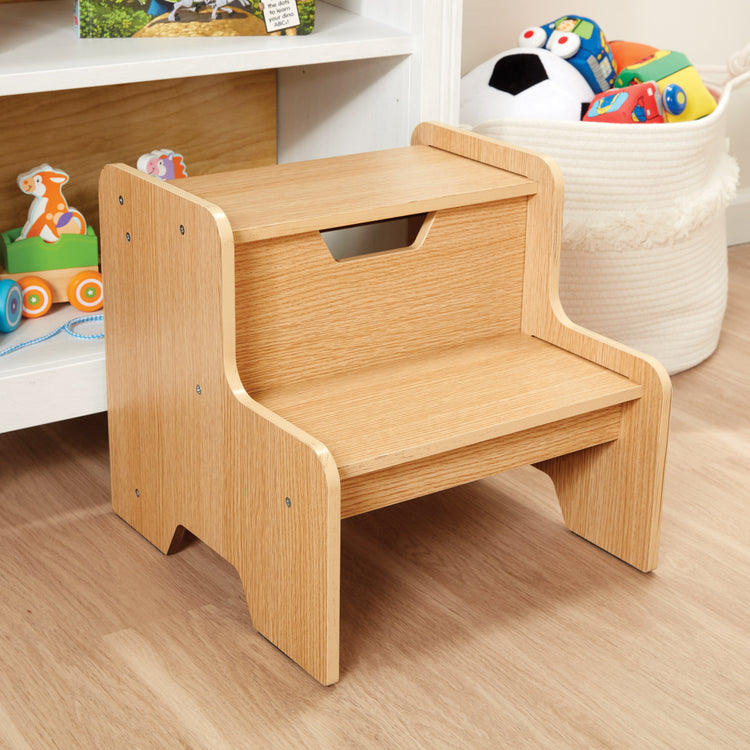 A kid playing with The Melissa & Doug Kids Wooden Step Stool - Light Natural Finish