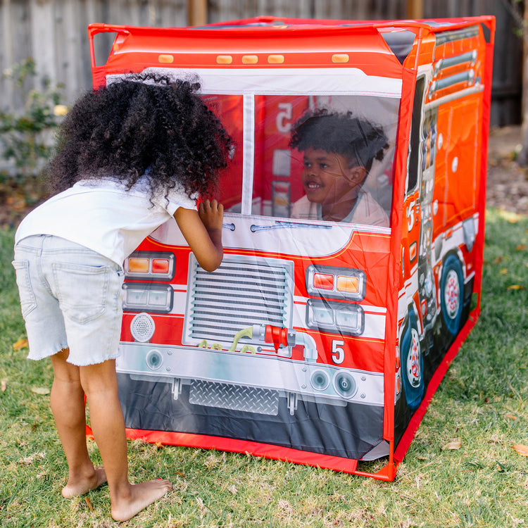 A kid playing with The Melissa & Doug Fire Truck Play Tent