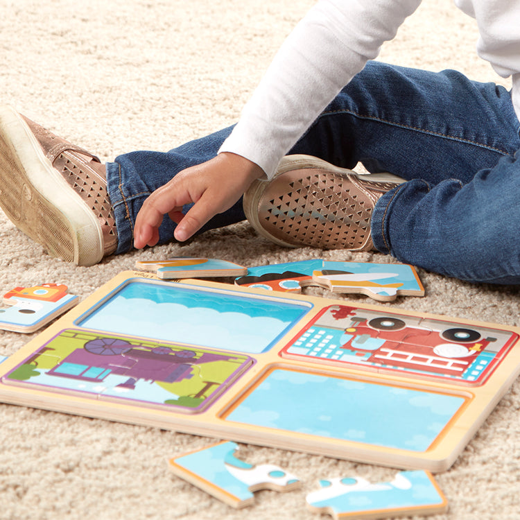 A kid playing with The Melissa & Doug Natural Play Wooden Puzzle: Ready, Set, Go (Four 4-Piece Vehicle Puzzles)