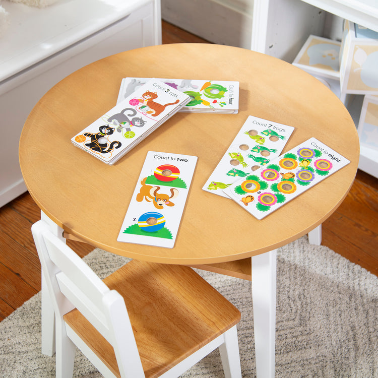 A playroom scene with The Melissa & Doug Poke-A-Dot Jumbo Number Learning Cards - 13 Double-Sided Numbers, Shapes, and Colors Cards with Buttons to Pop