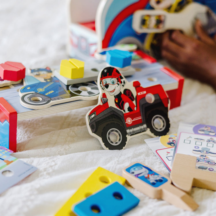 A kid playing with The Melissa & Doug PAW Patrol Match & Build Mission Cruiser