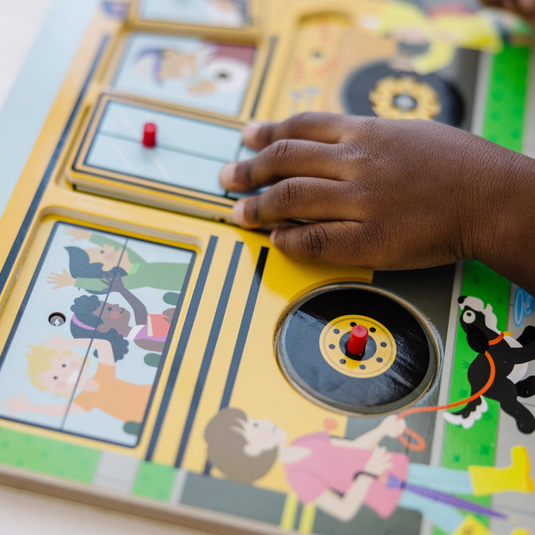 A kid playing with The Melissa & Doug The Wheels on the Bus Sound Puzzle