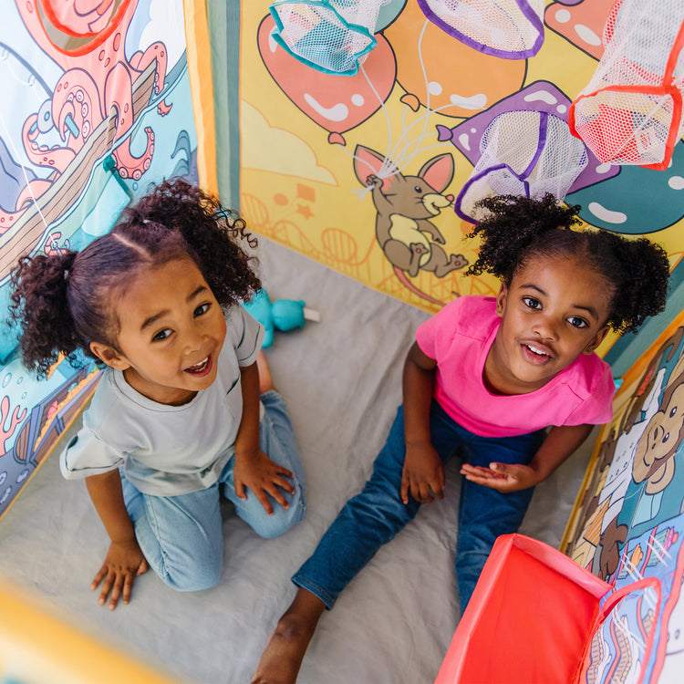 A kid playing with The Melissa & Doug Fun at the Fair! Game Center Play Tent – 4 Sides of Activities