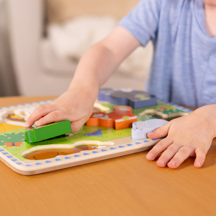 A kid playing with The Melissa & Doug Pets Wooden Chunky Puzzle (8 pcs)