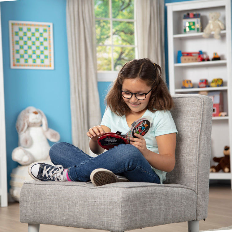 A kid playing with The Melissa & Doug Children’s Book - Math Gear Division Fast Facts Interactive Board Book