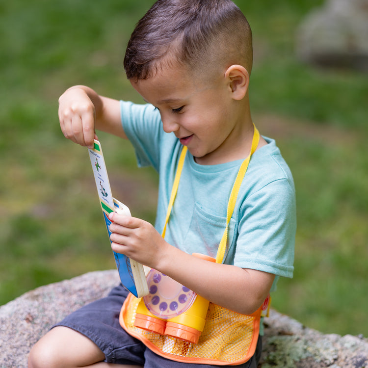 A kid playing with The Melissa & Doug Grand Canyon National Park Hiking Gear Play Set with Photo Disk Viewer