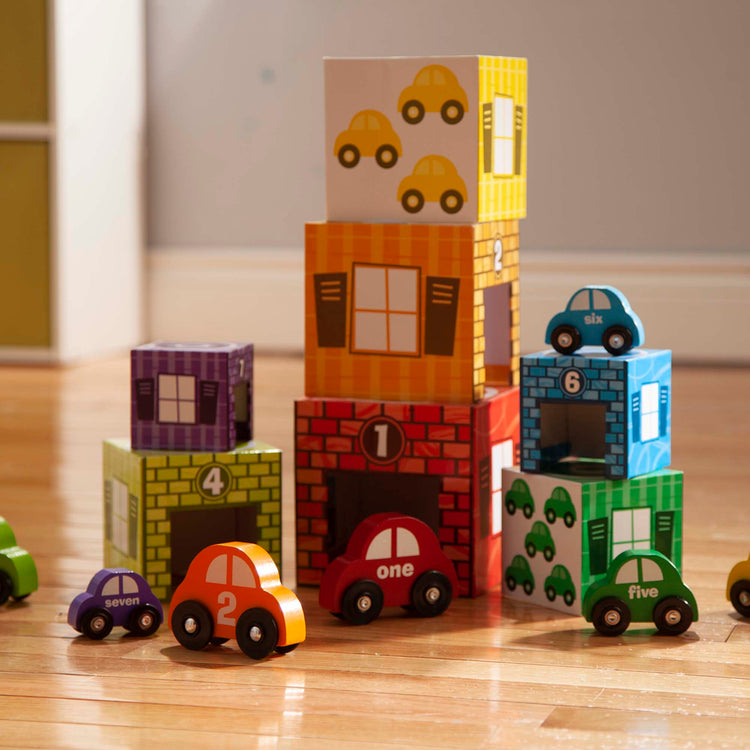 A playroom scene with The Melissa & Doug Nesting and Sorting Garages and Cars With 7 Graduated Garages and 7 Stackable Wooden Cars