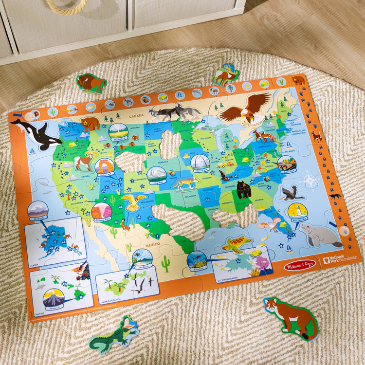 A kid playing with The Melissa & Doug National Parks U.S.A. Map Floor Puzzle – 45 Jumbo and Animal Shaped Pieces, Search-and-Find Activities, Park and Animal ID Guide