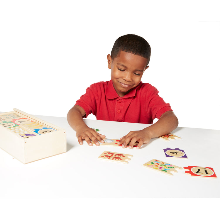 A child on white background with The Melissa & Doug Self-Correcting Wooden Number Puzzles With Storage Box (40 pcs)