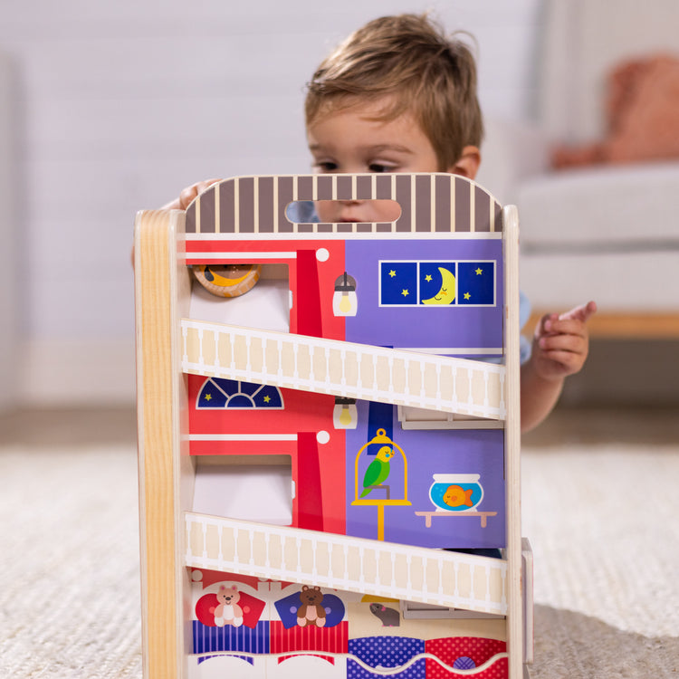 A kid playing with The Melissa & Doug GO Tots Wooden Town House Tumble with 6 Disks