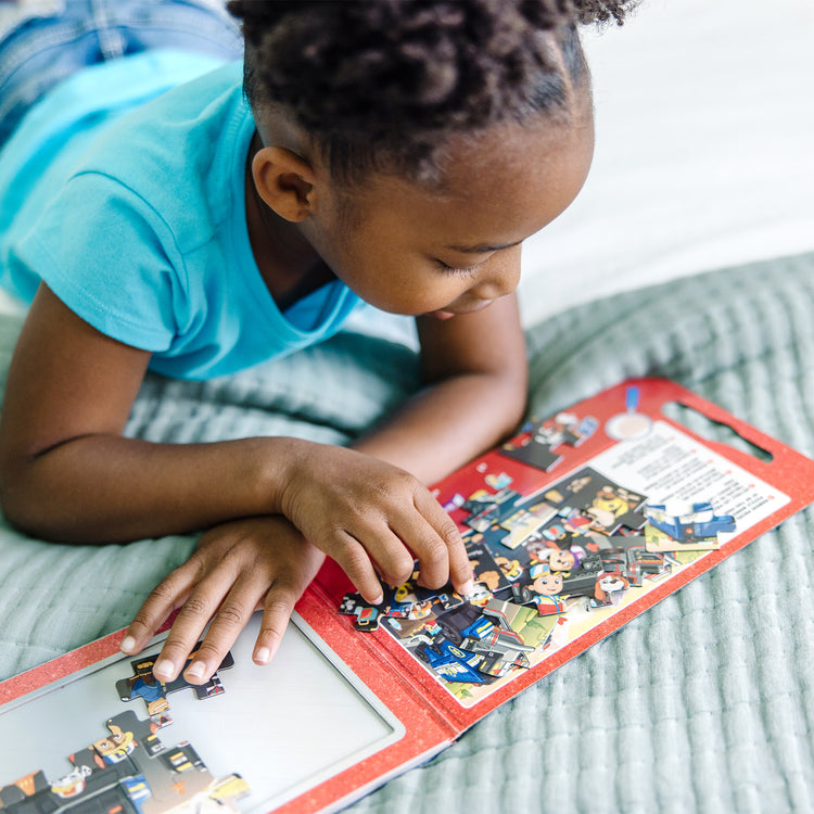 A kid playing with The Melissa & Doug PAW Patrol Take-Along Magnetic Jigsaw Puzzles - Big Truck Pups (2 15-Piece Puzzles)