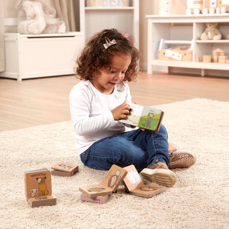 A kid playing with The Melissa & Doug Children's Book - Natural Play Book Tower: Little Learning Books