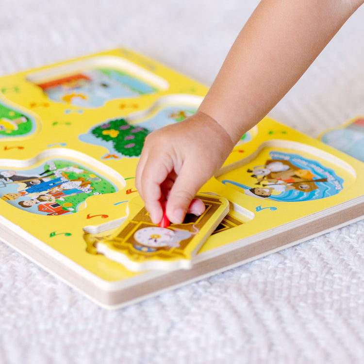 A kid playing with The Melissa & Doug Nursery Rhymes 1 Sound Puzzle - 6 PIeces