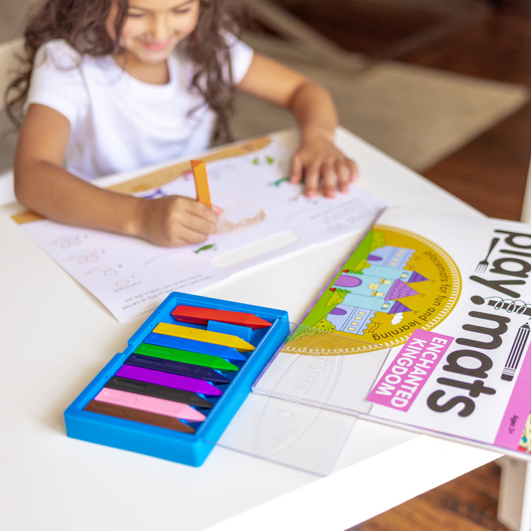 A kid playing with The Melissa & Doug Playmats Enchanted Kingdom Take-Along Paper Coloring And Learning Activity Pads (24 Pages)