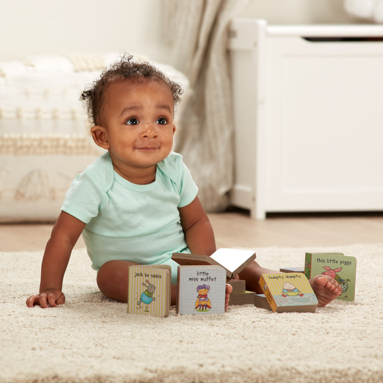 A kid playing with The Melissa & Doug Children's Book - Natural Play Book Tower: Little Nursery Books