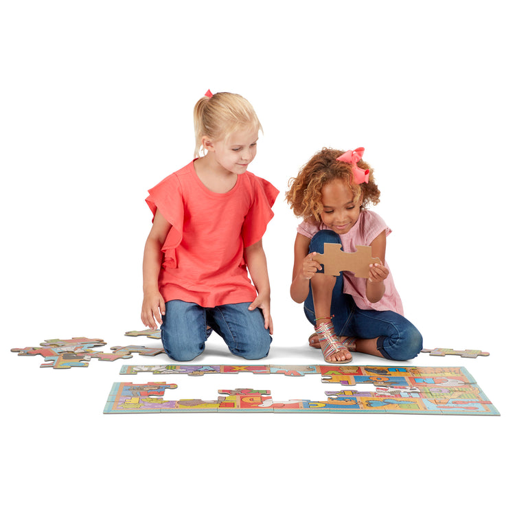 A child on white background with The Melissa & Doug Natural Play Giant Floor Puzzle: ABC Animals (35 Pieces)