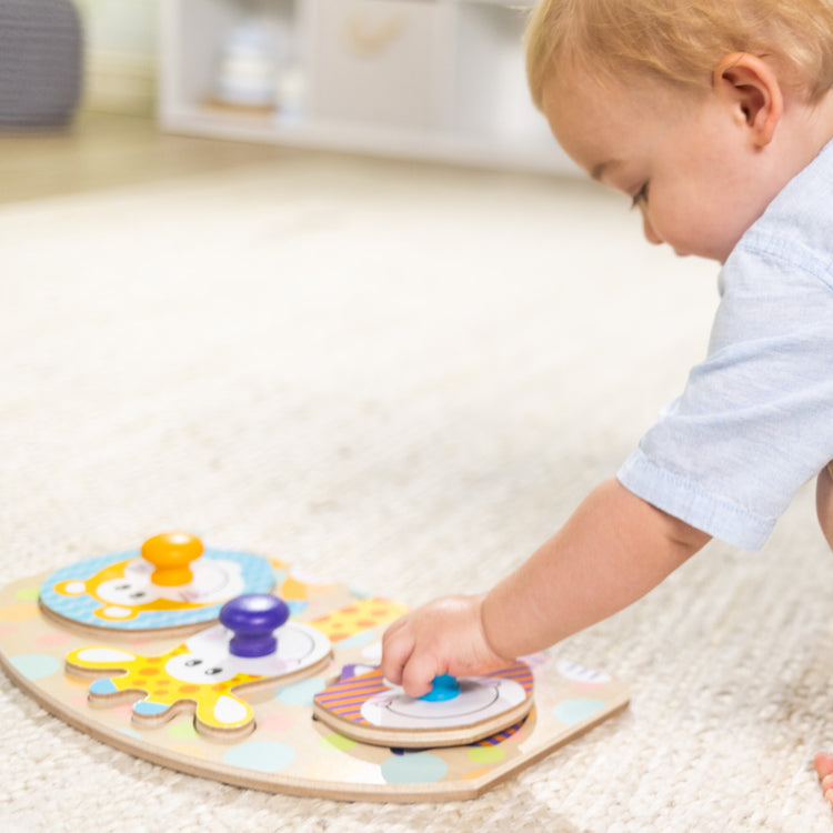 A kid playing with The Melissa & Doug First Play Wooden Jumbo Knob Safari Animal Puzzle (3 pcs)