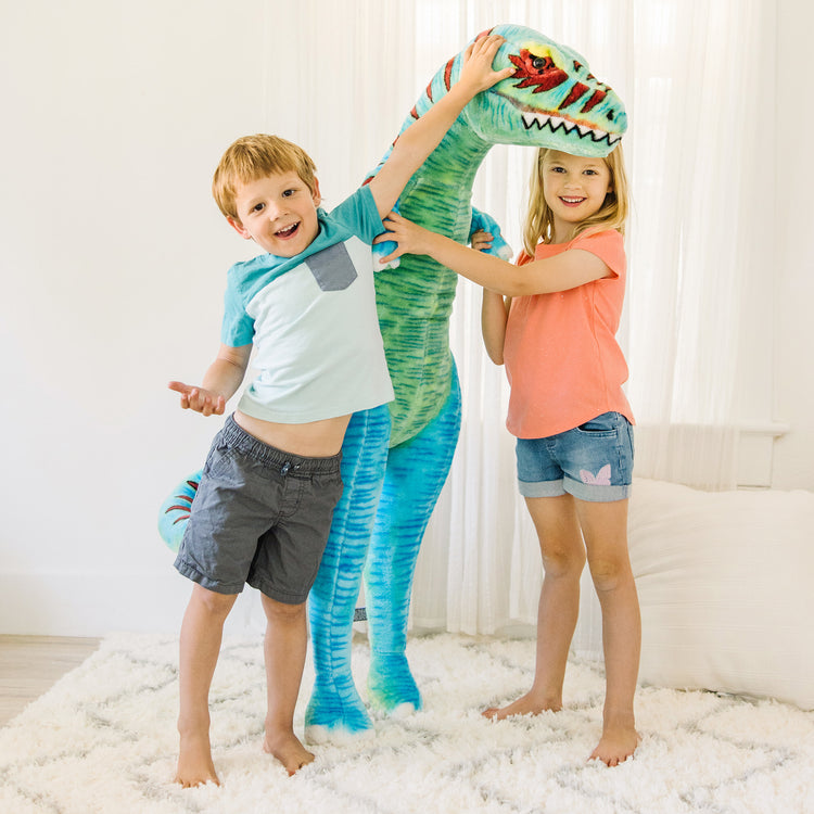 A kid playing with The Melissa & Doug Standing T-Rex Giant Lifelike Plush Stuffed Animal