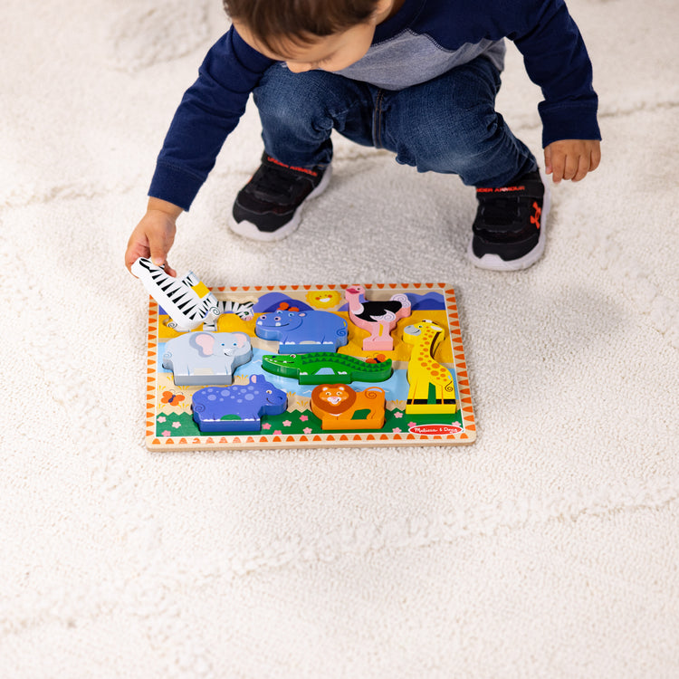 A kid playing with The Melissa & Doug Safari Wooden Chunky Puzzle - 8 Pieces