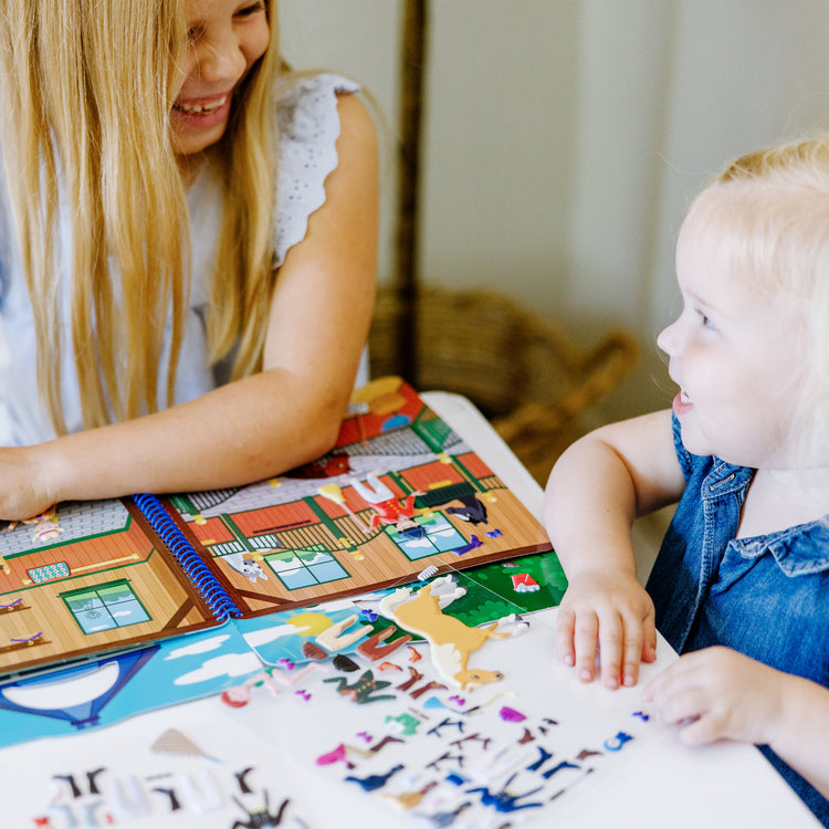 A kid playing with The Melissa & Doug Puffy Sticker Activity Book: Riding Club - 139 Reusable Stickers