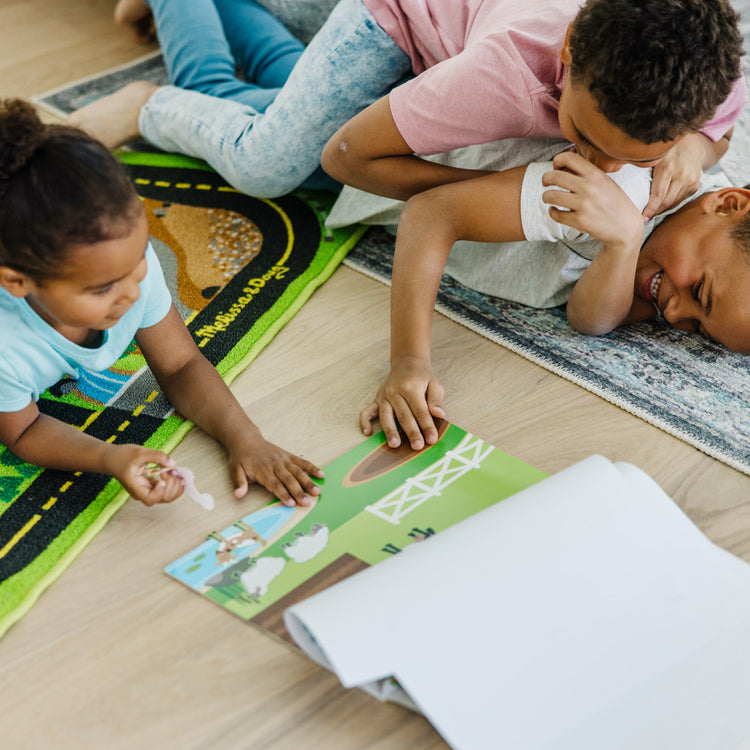 A kid playing with The Melissa & Doug Reusable Sticker Pad: Habitats - 150+ Reusable Stickers