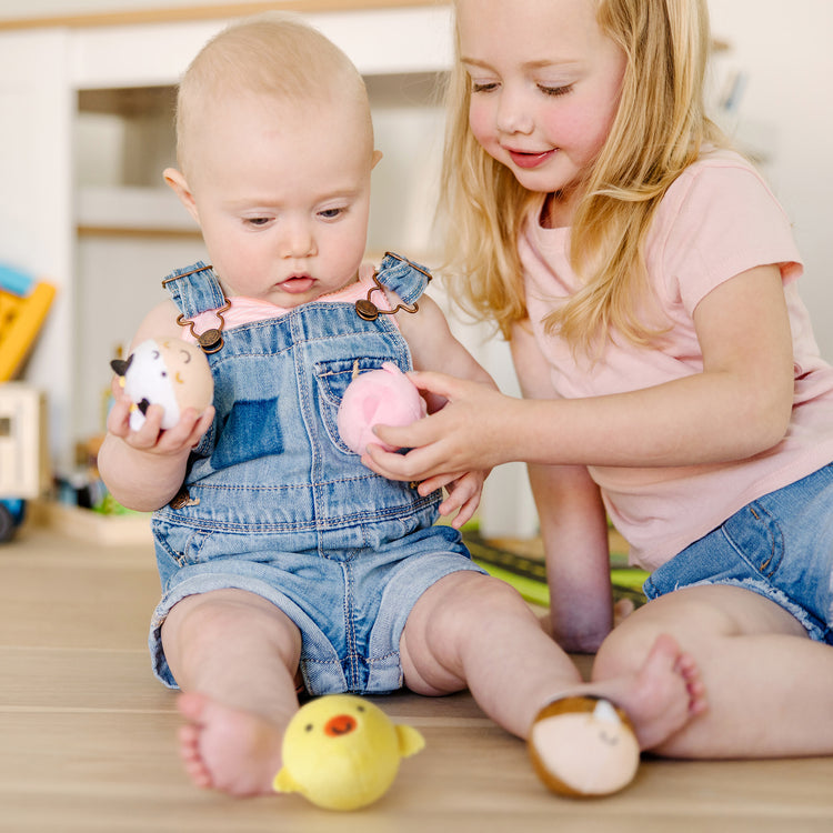 A kid playing with The Melissa & Doug Rollables Farm Friends Infant and Toddler Toy (4 Pieces)