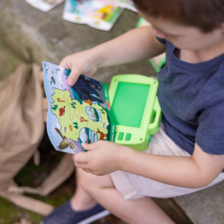 A kid playing with The Melissa & Doug Rocky Mountain National Park Sights and Sounds Wooden Toy Camera Play Set