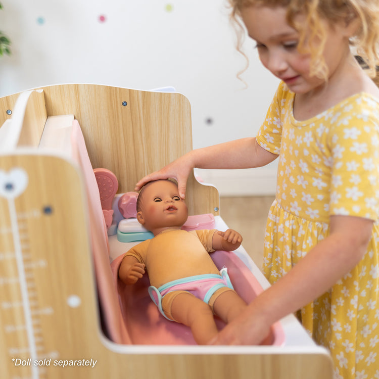 A kid playing with The Melissa & Doug Baby Care Center and Accessory Sets