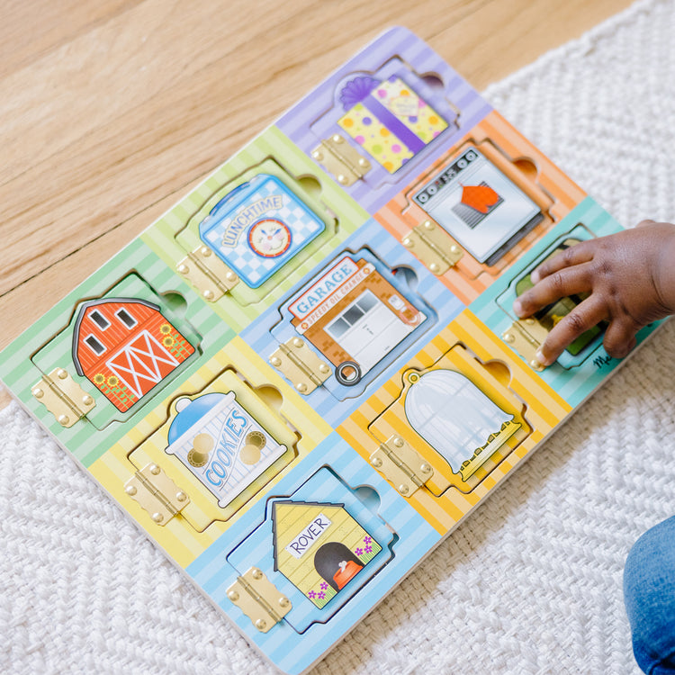 A kid playing with The Melissa & Doug Hide and Seek Wooden Activity Board With Wooden Magnets