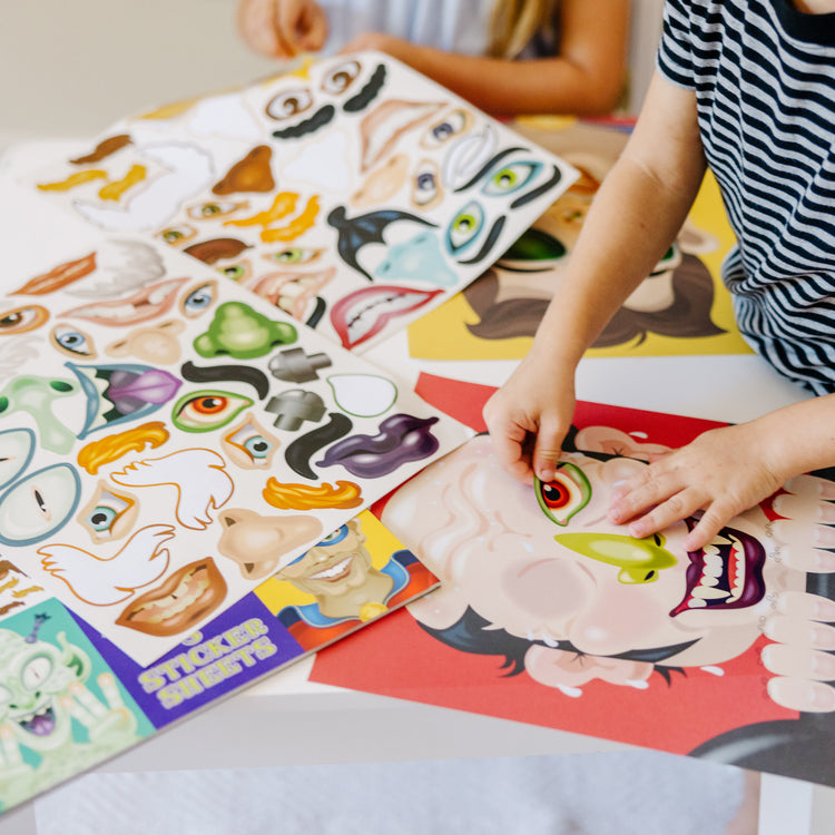 A kid playing with The Melissa & Doug Make-a-Face Sticker Pad - Crazy Characters, 20 Faces, 5 Sticker Sheets