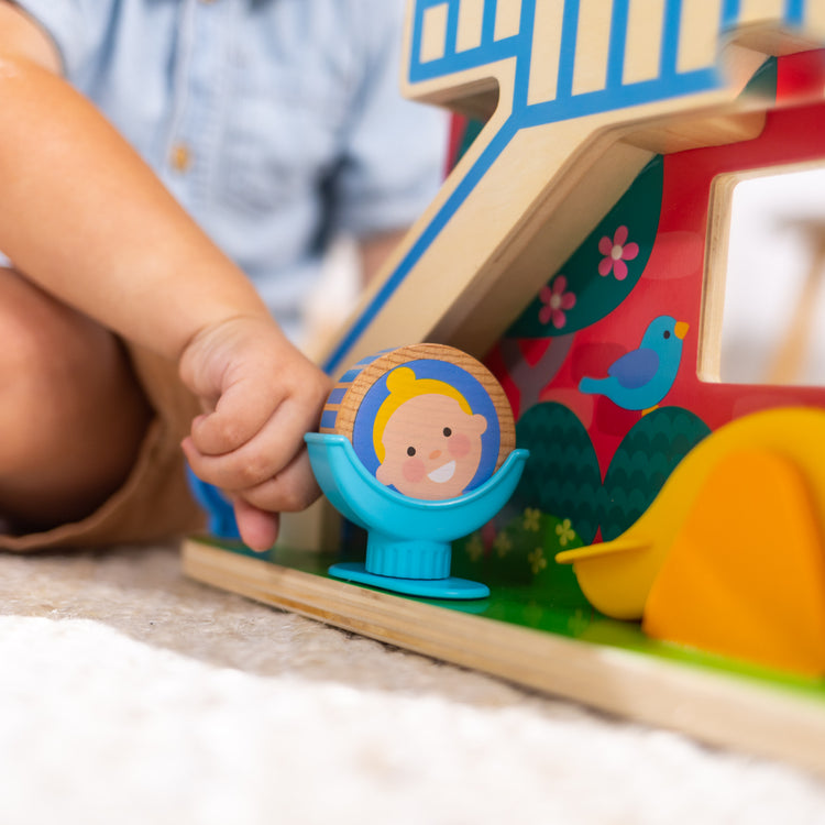 A kid playing with The Melissa & Doug GO Tots Wooden Schoolyard Tumble with 4 Disks