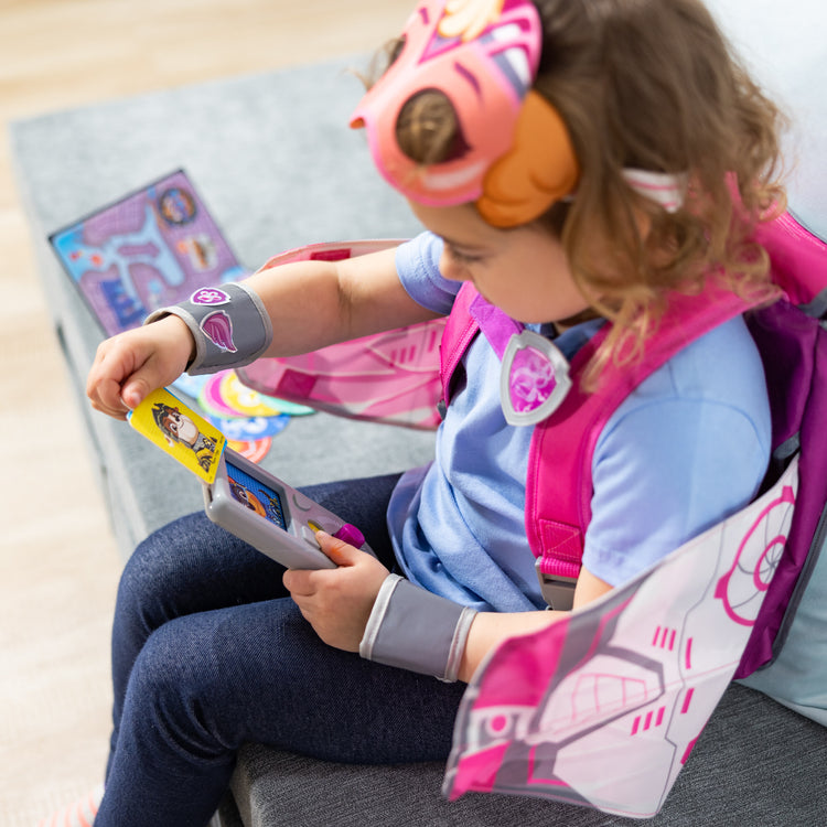 A kid playing with The Melissa & Doug PAW Patrol™ The Mighty Movie Mighty Skye Role Play Pack with Wings for Toddlers and Kids Age 3+