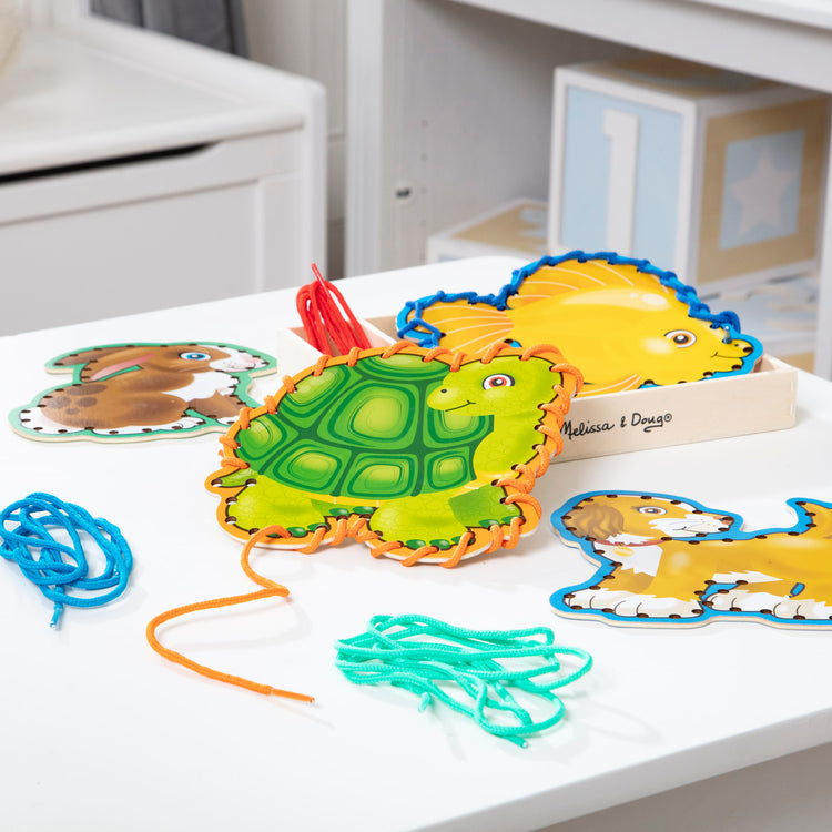 A playroom scene with The Melissa & Doug Lace and Trace Activity Set: Pets - 5 Wooden Panels and 5 Matching Laces