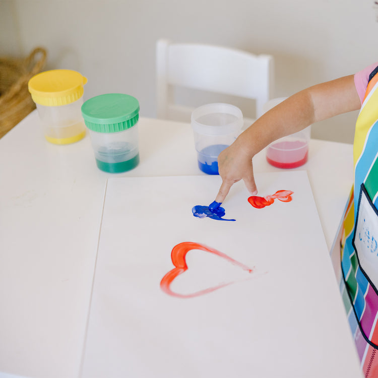 A kid playing with The Melissa & Doug Finger Paint Paper Pad - 50 12"x18" Sheets for Kids Arts And Crafts Age 2+