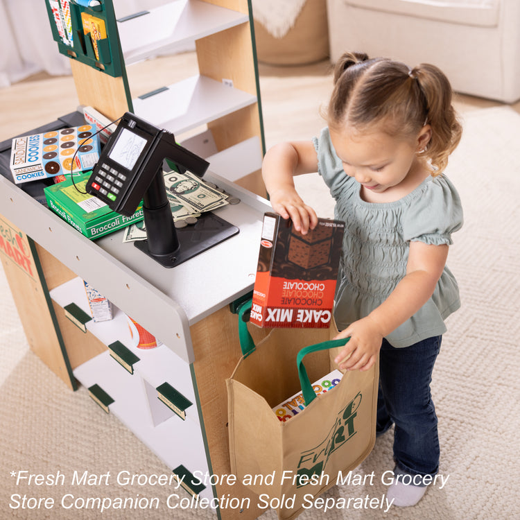 A kid playing with The Melissa & Doug Freestanding Wooden Fresh Mart Grocery Store
