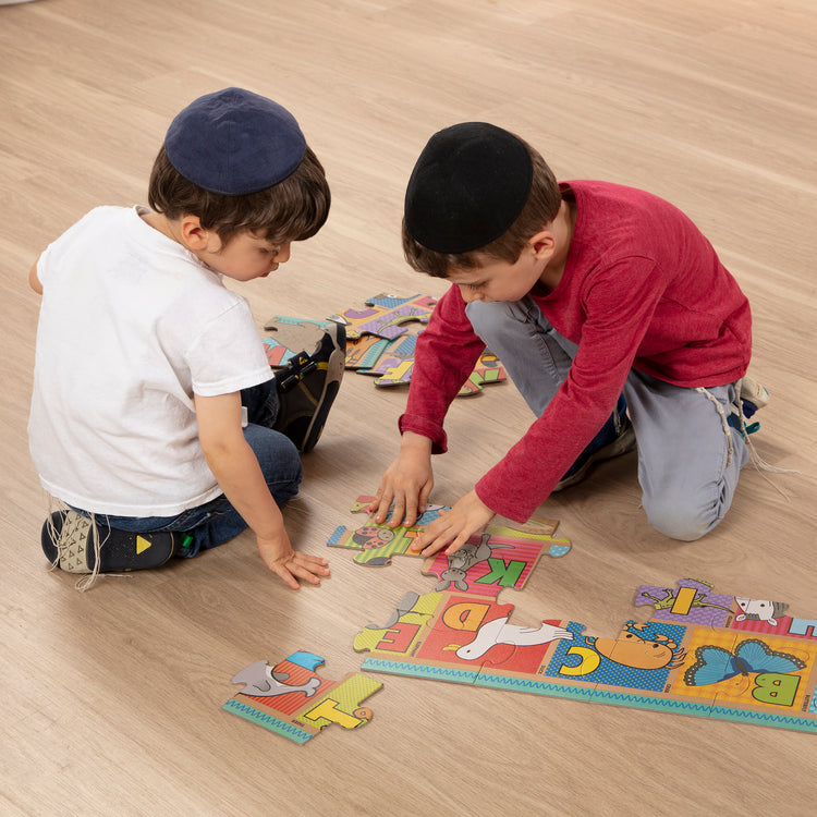 A kid playing with The Melissa & Doug Natural Play Giant Floor Puzzle: ABC Animals (35 Pieces)