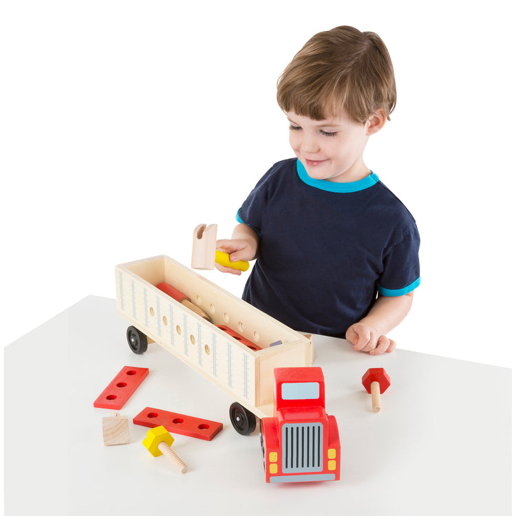 A child on white background with The Melissa & Doug Wooden Big Rig Truck Building Set (22 pcs)