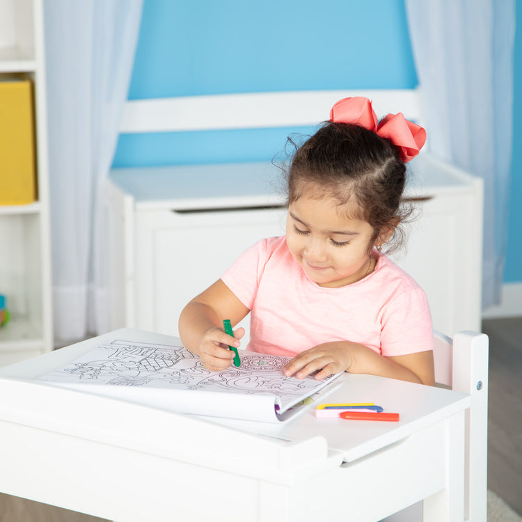 A kid playing with The Melissa & Doug Jumbo 50-Page Kids' Coloring Pad - Horses, Hearts, Flowers, and More