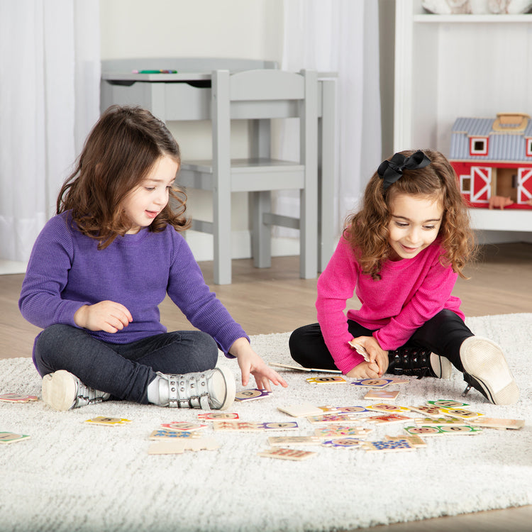 A kid playing with The Melissa & Doug Self-Correcting Wooden Number Puzzles With Storage Box (40 pcs)