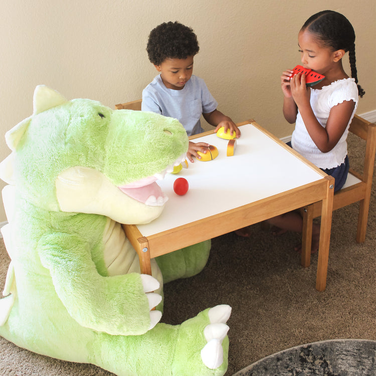 A kid playing with The Melissa & Doug Gentle Jumbos Dinosaur Giant Stuffed Plush Animal (Sits Nearly 3 Feet Tall)